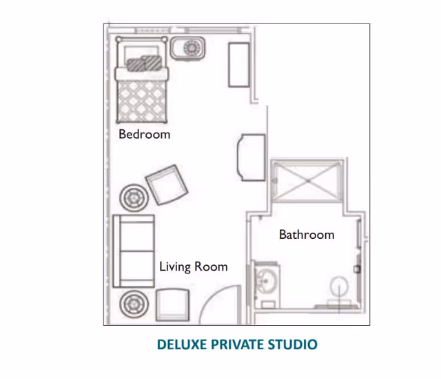 Floor plan layout of a deluxe private studio showing a bedroom area with a bed and nightstand, a living room area with a sofa, chair, and table, and a separate bathroom with a sink, toilet, and shower.