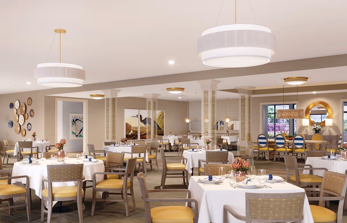 Spacious, well-lit dining room with multiple tables set with white linens, chairs, and pendant lights.