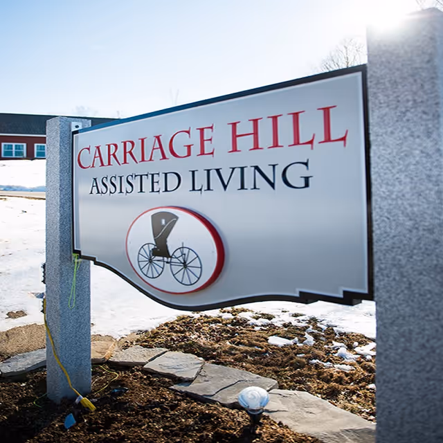 Outdoor sign for Carriage Hill Assisted Living with a wheelchair logo.