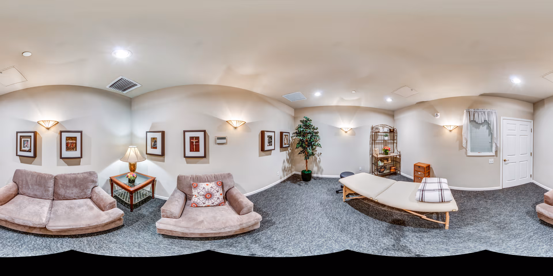 Cozy lounge area with comfortable seating, artwork, and decorative plants.