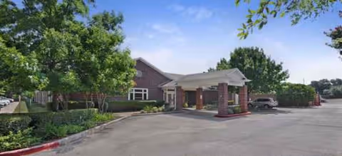 Exterior view of Brookdale North Austin building front with driveway and entrance.
