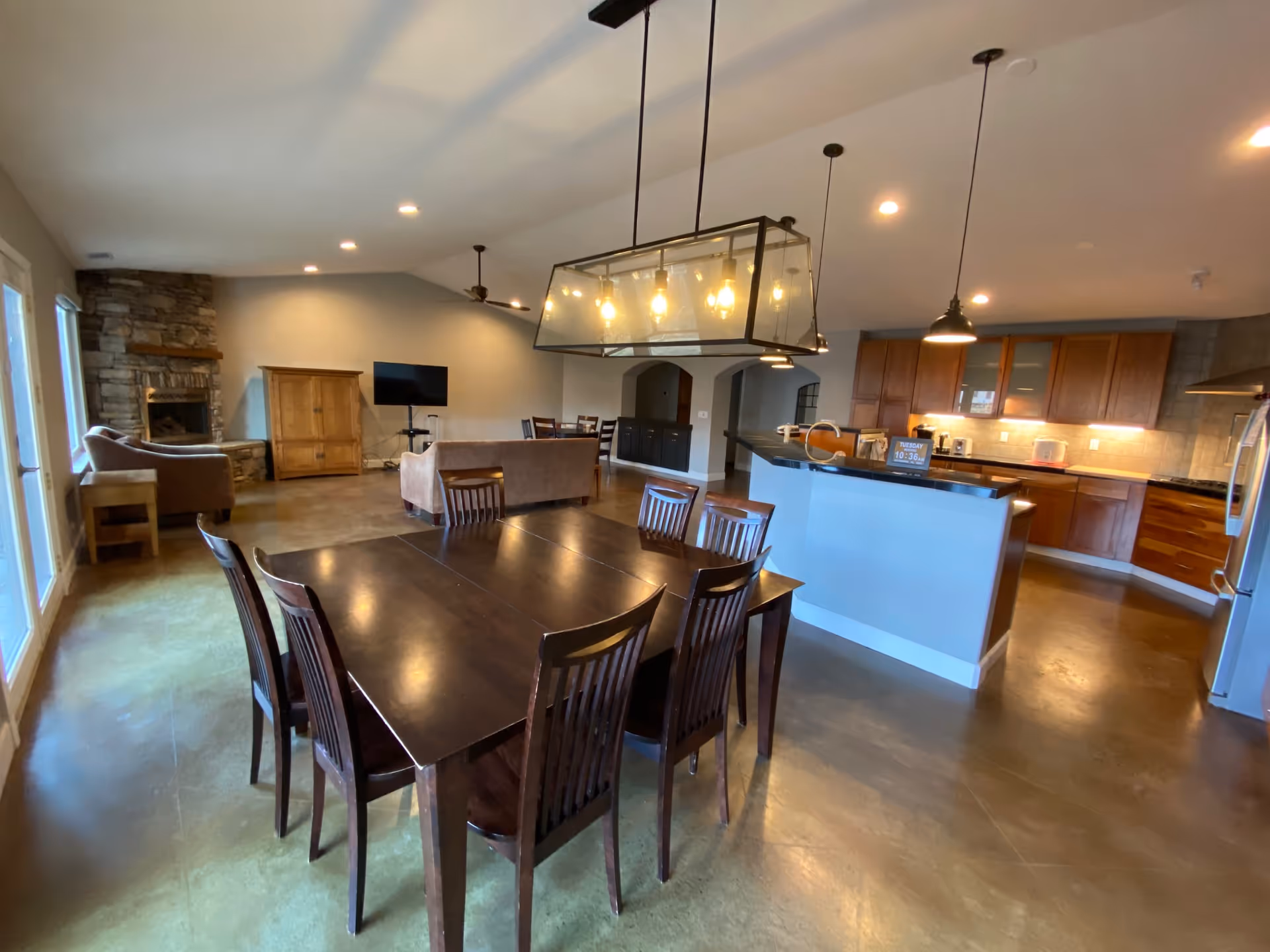 Open-concept dining and kitchen area with dark wood table, island, and seating.