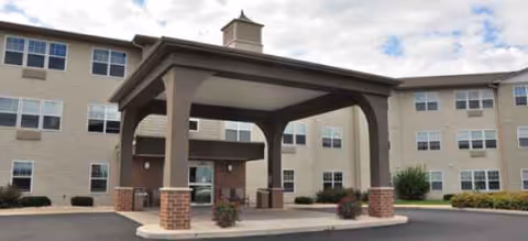 Exterior view of a multi-story senior living building with a covered entrance.