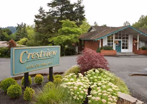 Exterior view of Avamere Crestview of Portland with a sign and landscaped entrance.