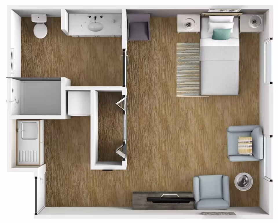 Top-down view of a floor plan showing a small living space with a bedroom area containing a single bed, two nightstands, a rug, and two armchairs. The bathroom includes a toilet, sink, and shower. There is also a small kitchenette with a sink and counter space.