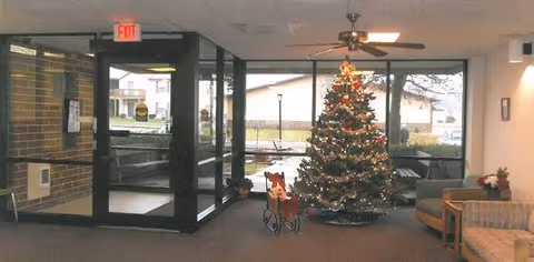 Mattoon Tower lobby features glass doors, a Christmas tree, seating, and a ceiling fan.