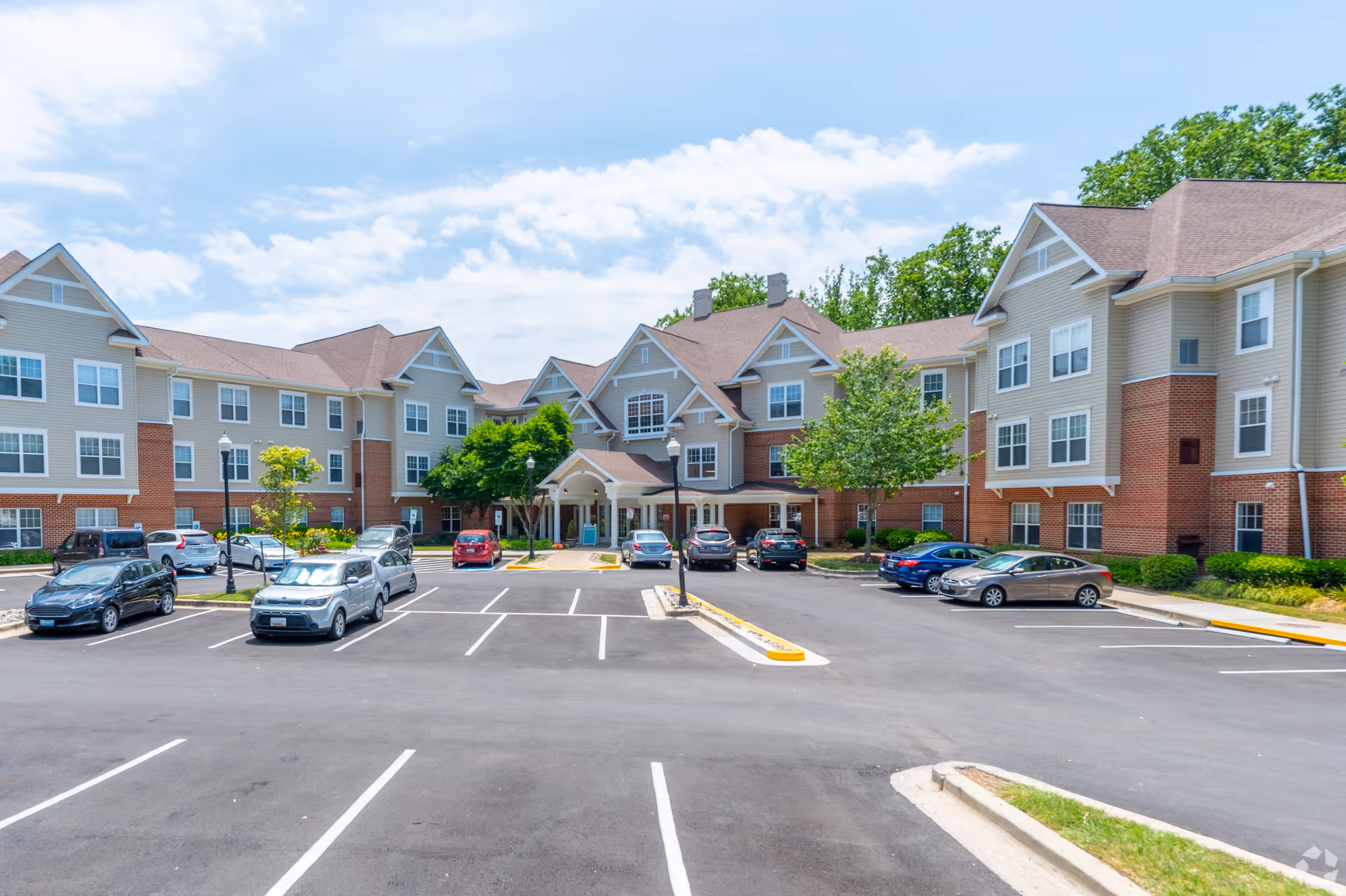 Exterior view of Manor at Colesville, a multi-building senior living campus with a parking lot.