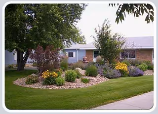 Well-manicured front lawn and shrubs frame a single-story building facade.
