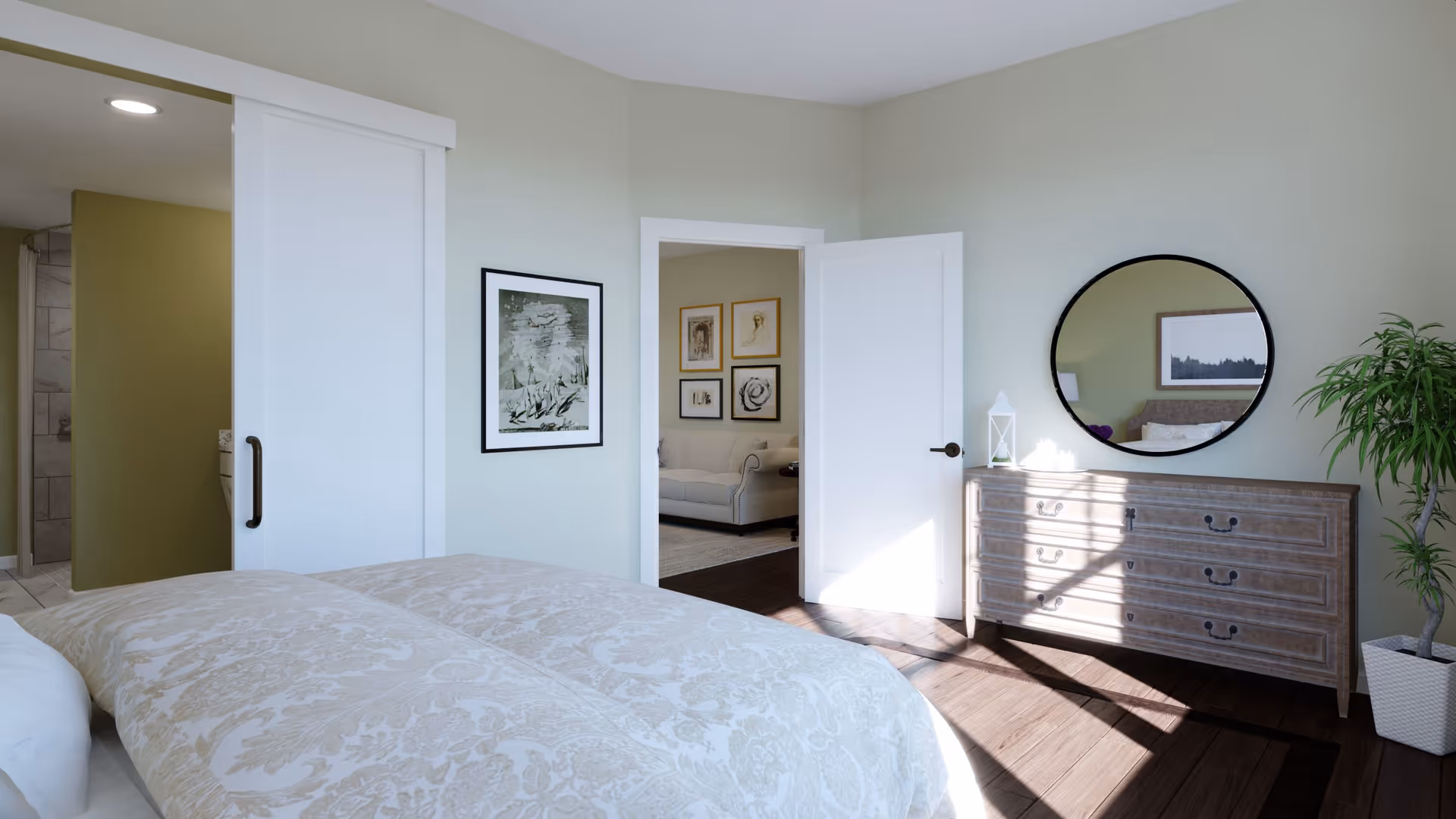 Bright bedroom with a patterned bedspread, wooden dresser topped by a round mirror, sliding door to a bathroom, and an open doorway to a sitting room.