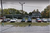 Exterior view of Lynhurst Healthcare with a row of parked cars in front of the facility.
