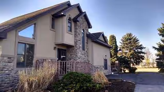 Exterior view of a Pond View Manor building with stone accents and front entrance.