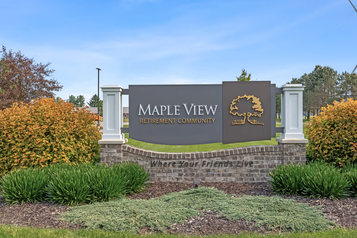 Maple View Retirement Community entrance sign with landscaping and brick base.