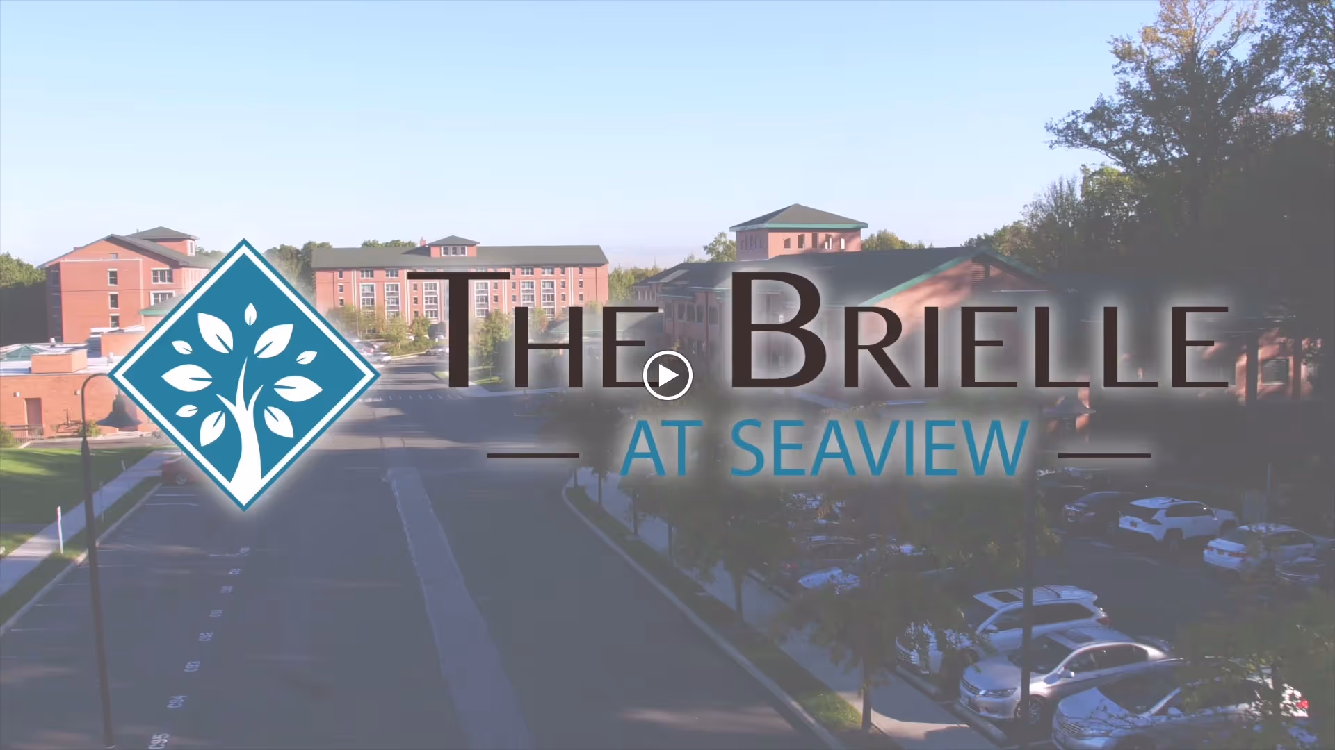 Aerial view of a senior living campus with brick buildings, a parking lot, and an overlaid logo reading 'THE BRIELLE AT SEAVIEW'.