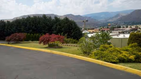 Outdoor view of Kadie Glen with landscaped shrubs and distant mountains.