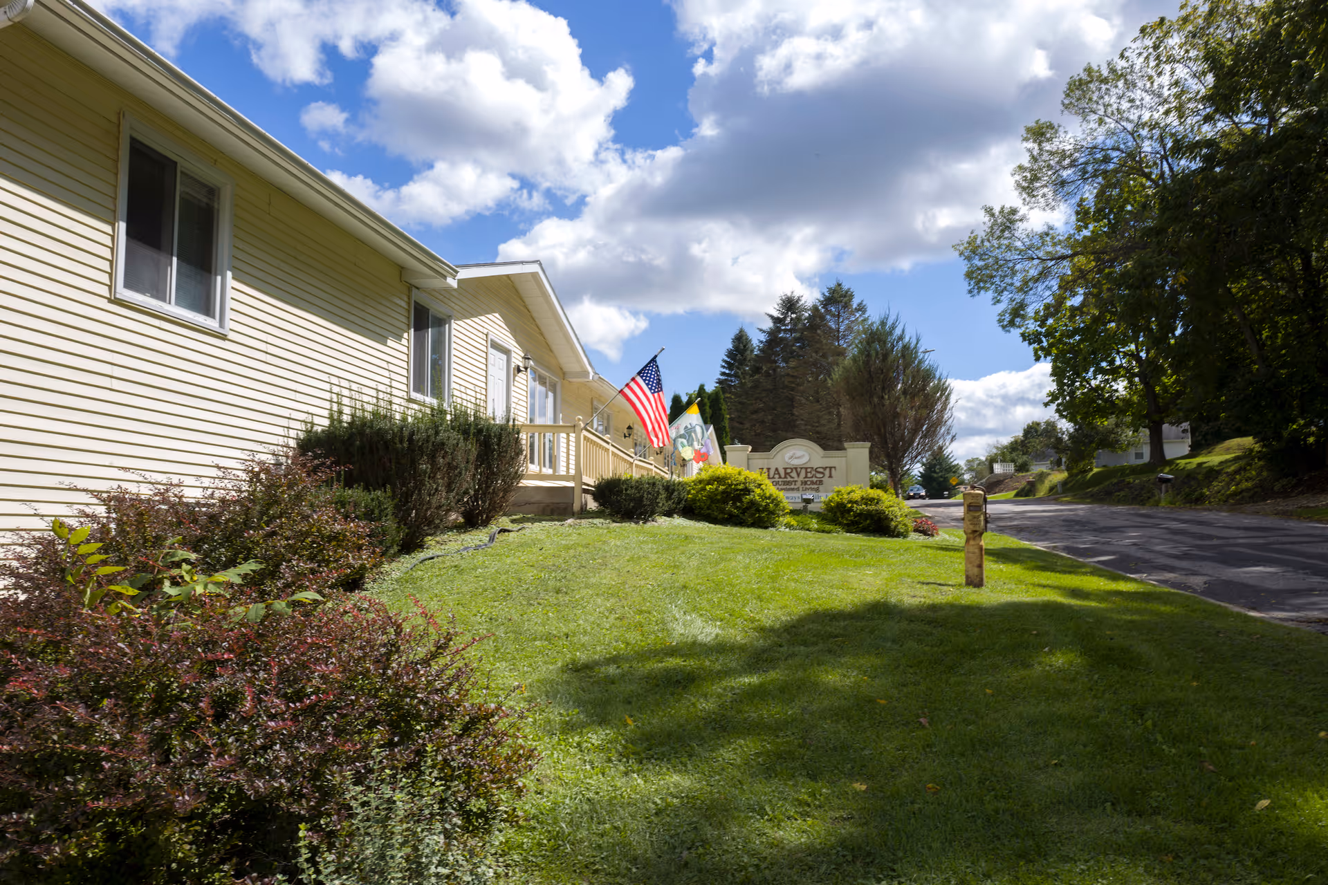 Front exterior view of Harvest Guest Home with lawn and driveway