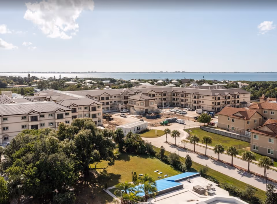 Aerial view of Discovery Village At Sarasota Bay, showing residential buildings and surrounding landscape.