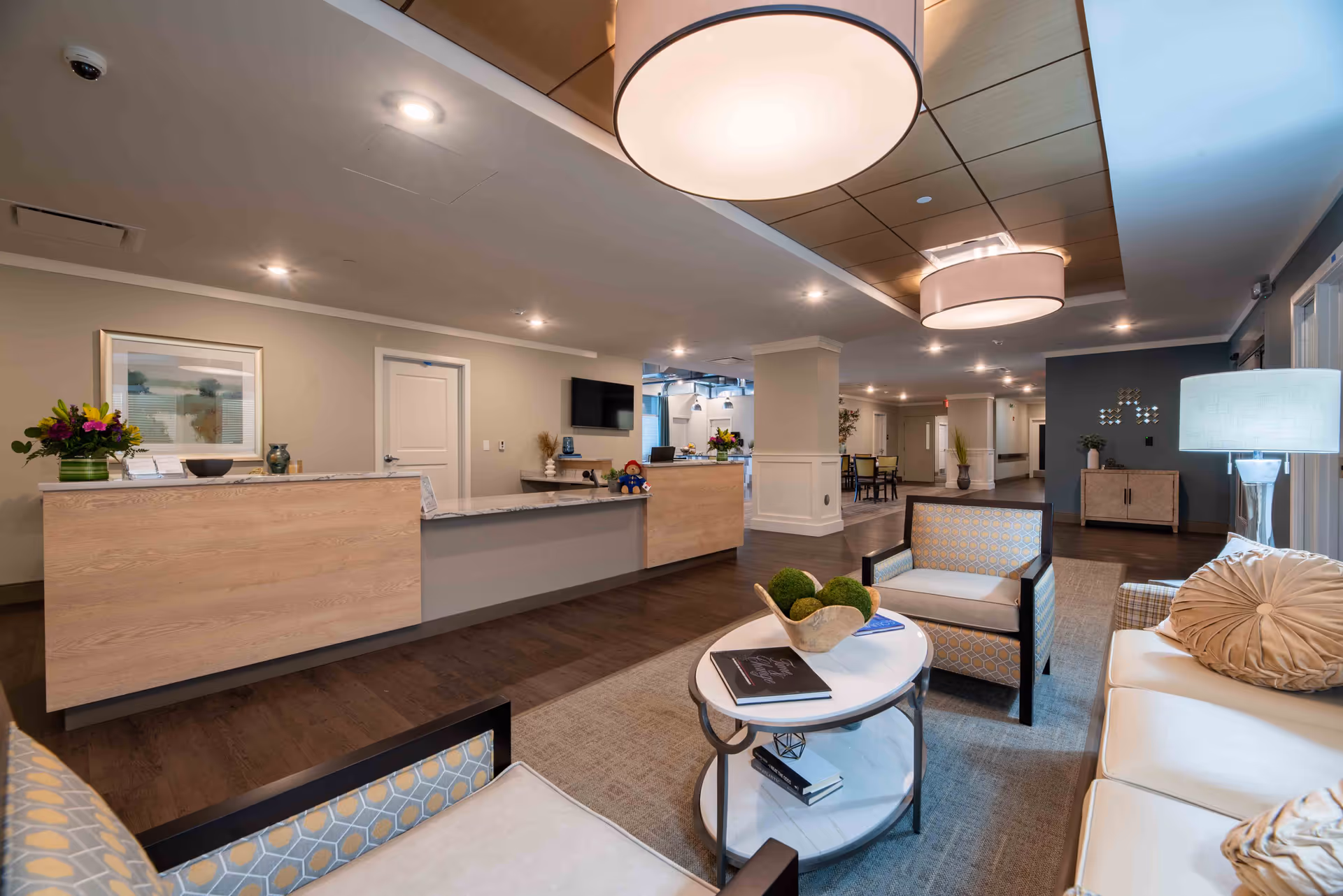 Spacious reception lounge with a front desk, seating area, and modern pendant lighting.