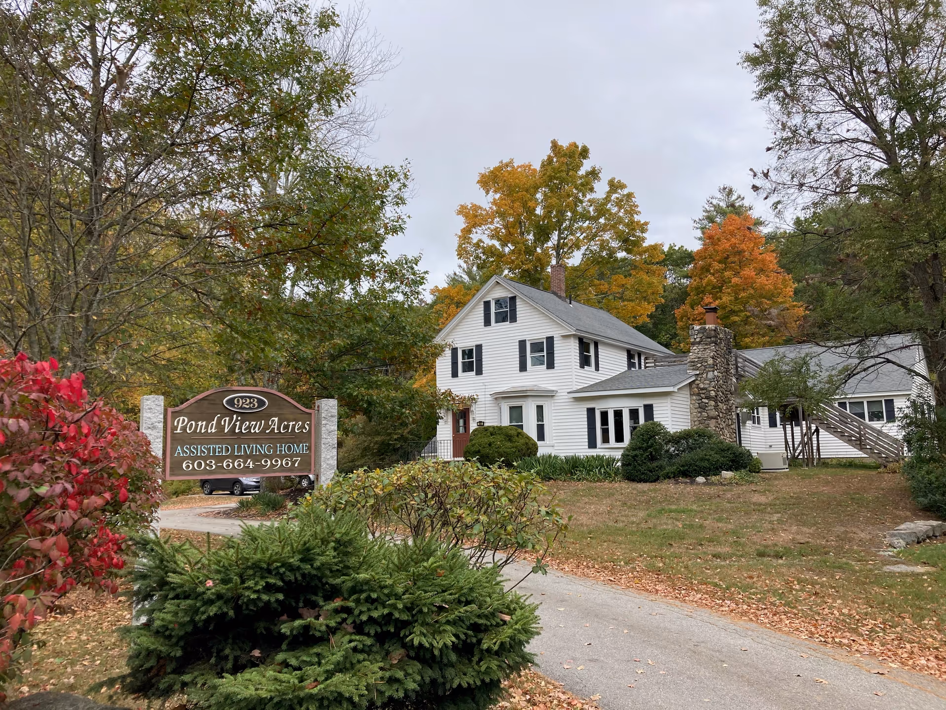 Exterior view of Pond View Acres Assisted Living facility surrounded by trees and foliage.