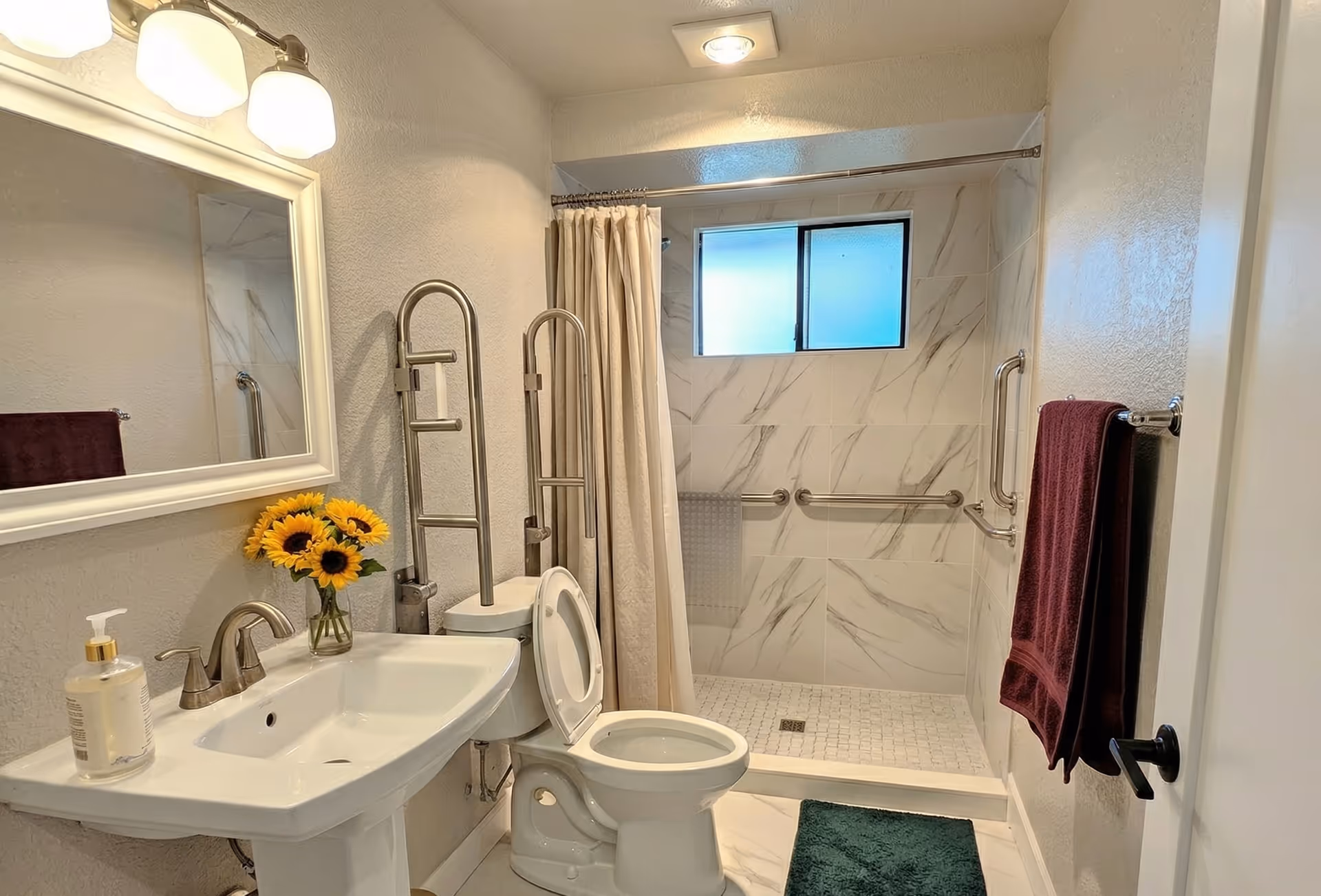 Accessible bathroom featuring a sink, toilet, walk-in shower with grab bars.