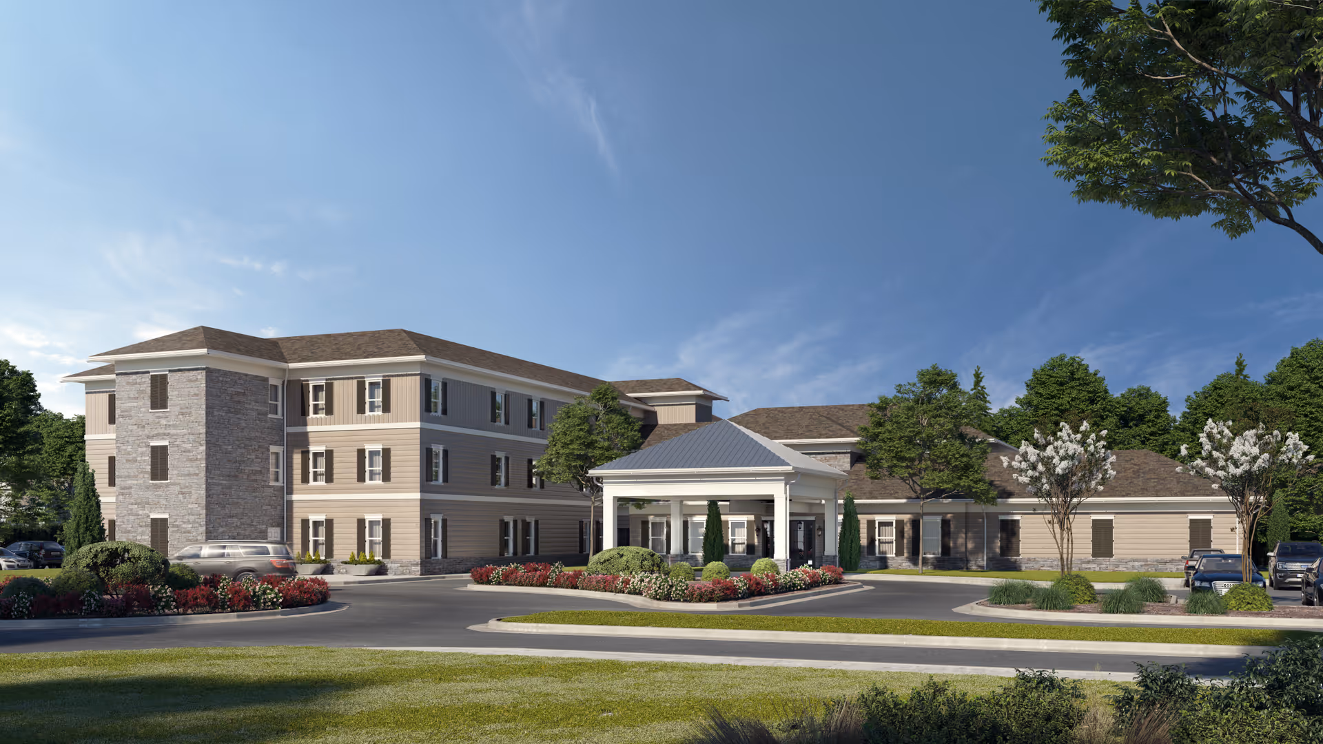 Exterior view of a three-story senior living facility building with beige siding and stone accents, a covered entrance with white columns, surrounded by landscaped greenery, trees, and parked cars under a clear blue sky.