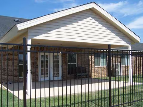 Exterior view of Good Life Senior Living and Memory Care with a fenced porch.