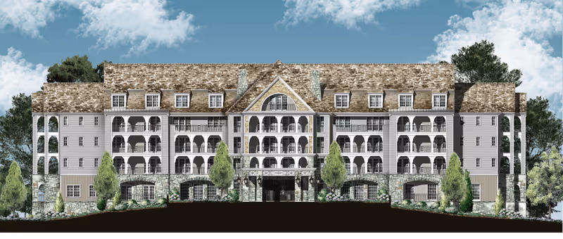 Rendering of the front facade of a multi-story senior living building with arched balconies, stone base, and pitched shingle roof against a cloudy sky.
