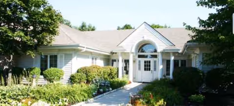 Front view of Brookdale Utica Memory Care entrance with shrubs.