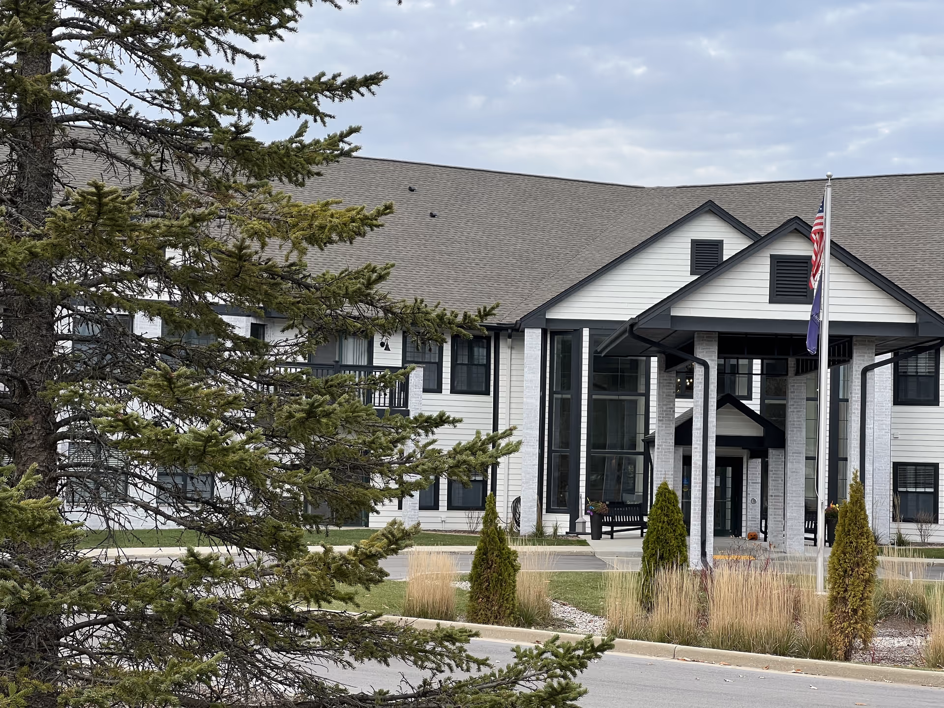 Front exterior view of Charter Senior Living of Mequon with landscaped greenery.