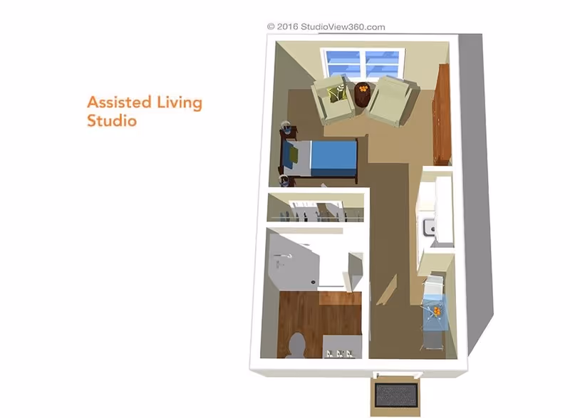 3D floor plan of an assisted living studio apartment showing a combined living and sleeping area with two armchairs, a bed, and a dresser. There is a kitchenette with a sink and a small table with a chair. The bathroom includes a shower, toilet, and sink. The entrance is at the bottom of the image.