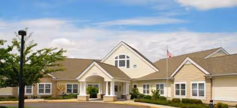 Front exterior of Brookdale Beaverton with entrance, columns, and landscaped area.