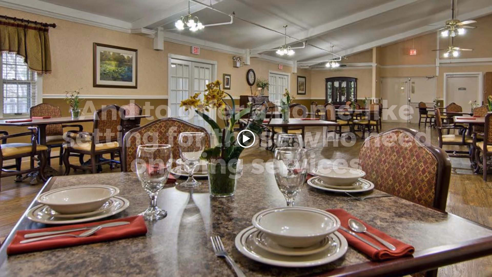 Dining room with multiple set tables, place settings, floral centerpieces, and upholstered chairs.