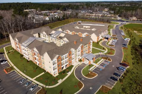 An aerial view of Heartis Fayetteville senior living campus showing buildings and a surrounding parking lot.