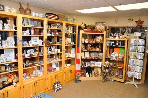 Gift shop at Grand Village senior living facility with wooden shelves and knick-knacks.
