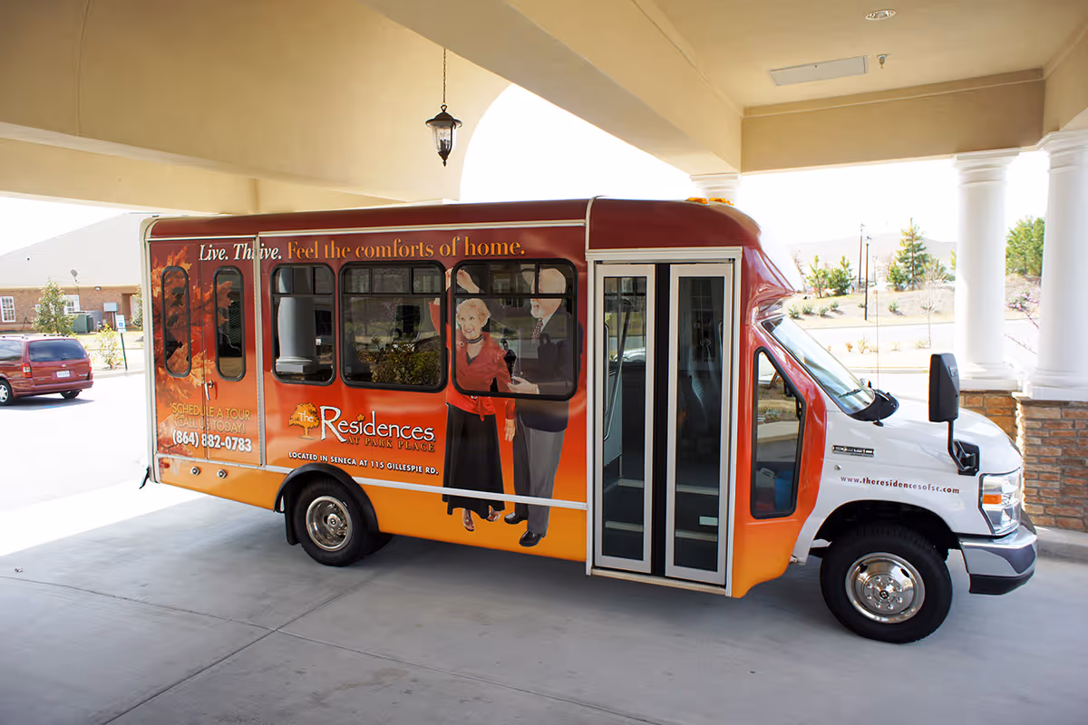 A shuttle bus branded for The Residences at Park Place parked under a covered entrance/portico.
