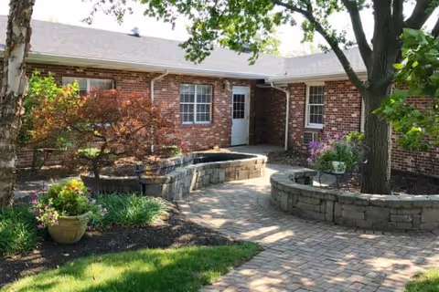 Brick exterior of Heritage Estates with a landscaped outdoor courtyard and curved stone planters.