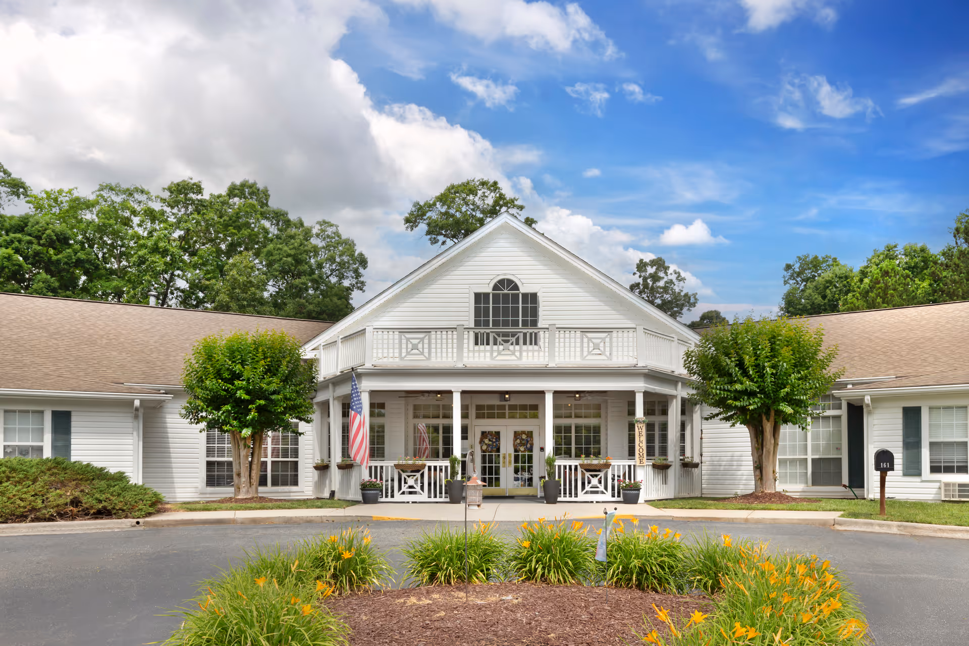 Brookdale Lexington exterior: white, single-story facility with central porch, flag, and manicured landscaping.