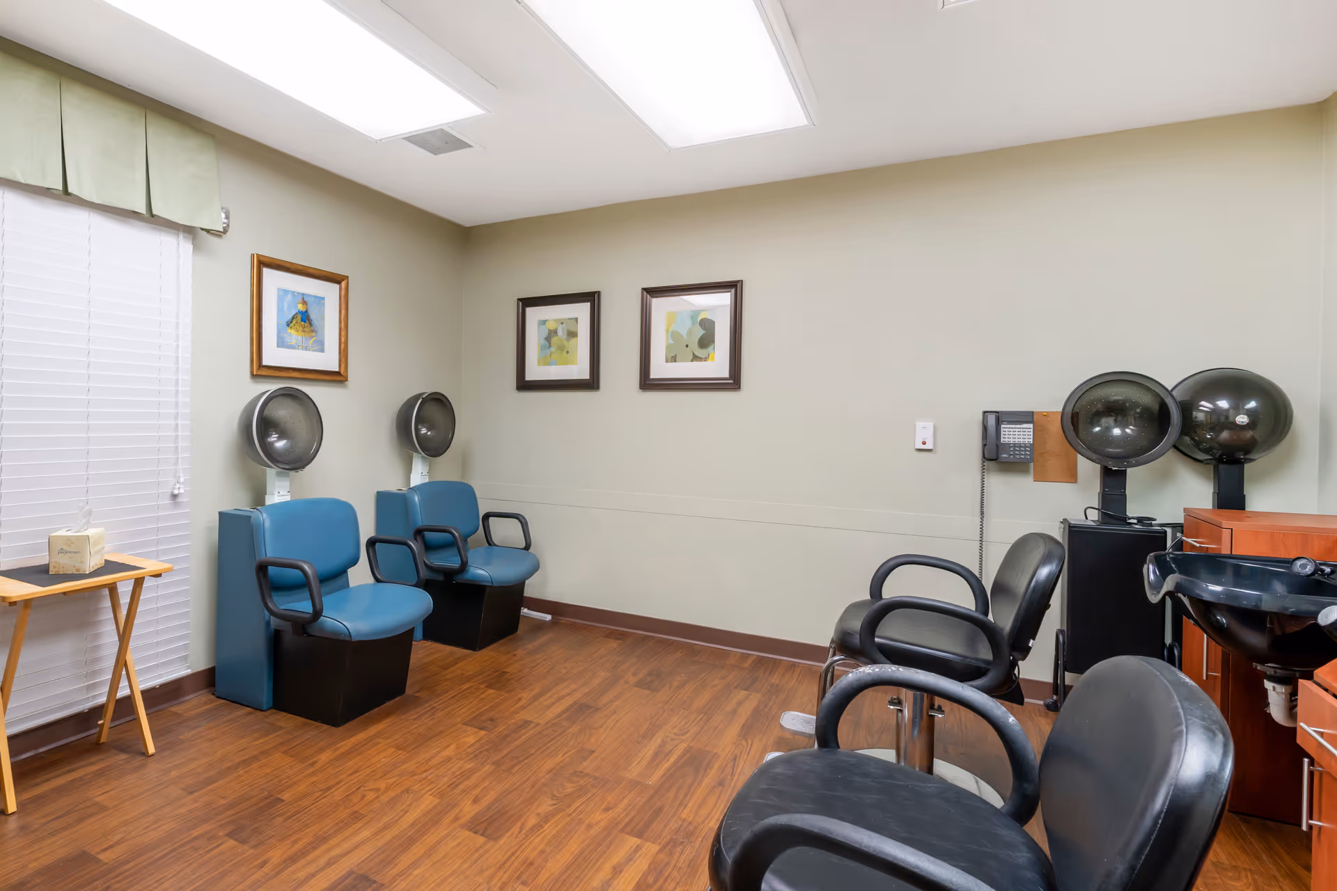 Small salon-style room with multiple hair-drying stations, salon chairs, and a wash basin.