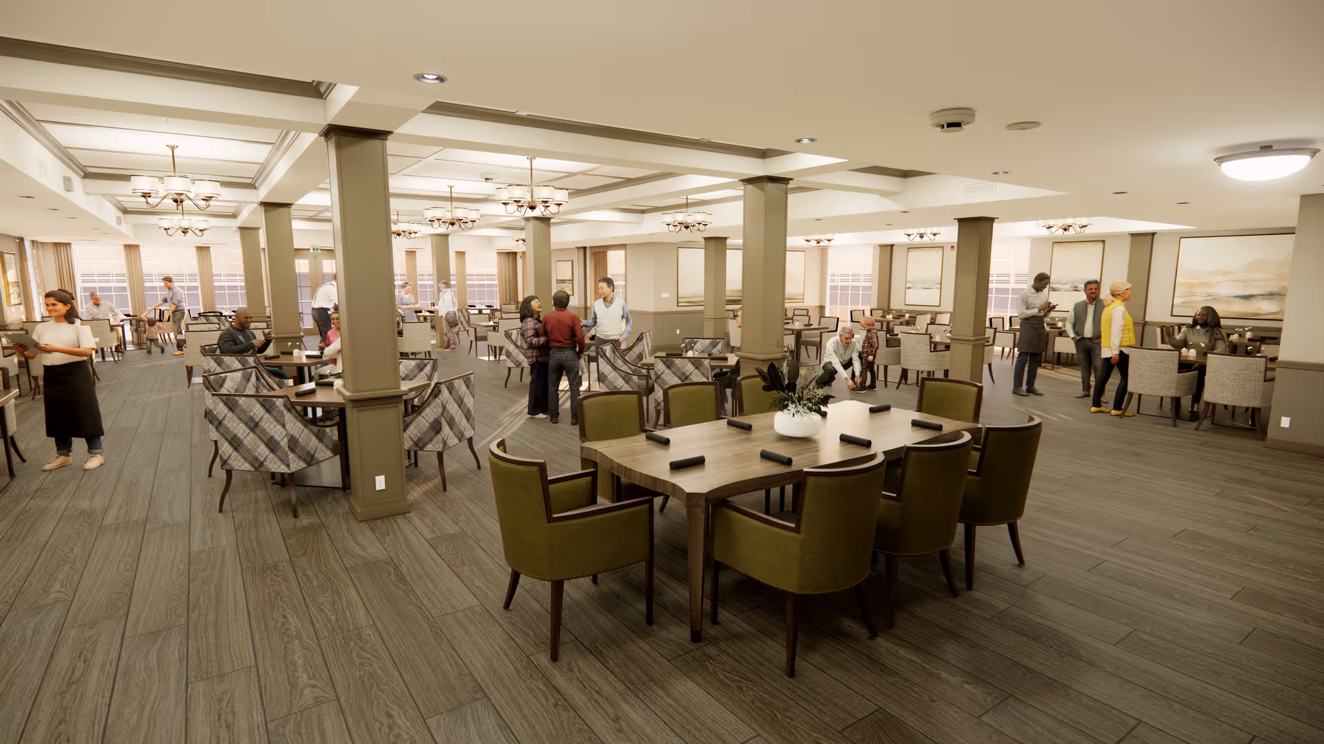 A spacious senior living dining room with multiple tables and chairs arranged neatly. Several seniors and staff members are interacting and walking around the room. The room features wooden flooring, beige walls, large windows allowing natural light, and ceiling lights with chandeliers.