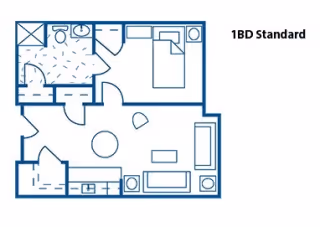 Floor plan layout of a 1-bedroom standard apartment showing a bedroom with a bed, a bathroom with a toilet and shower, a living area with seating and a table, and a kitchen area with appliances.