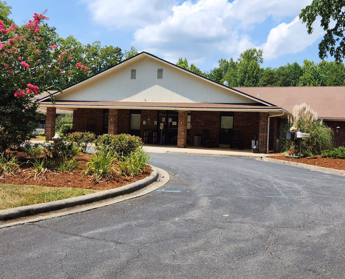 Front exterior of a single-story brick senior living center with a covered entrance.