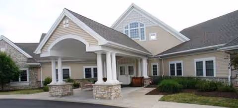 Exterior view of Brookdale Fayetteville entrance with arched portico, columns, and landscaped front.