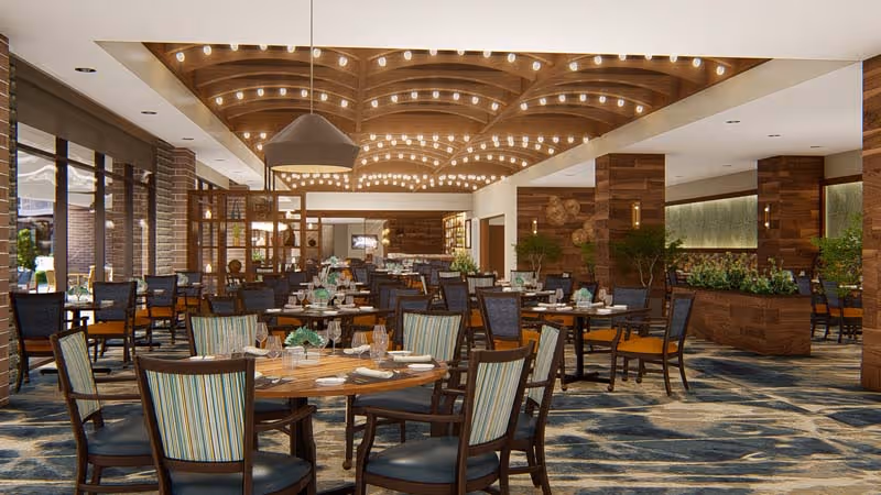 A spacious and elegantly designed dining room with multiple round tables set with plates, glasses, and cutlery. The room features wooden accents, a patterned carpet, large windows allowing natural light, and modern ceiling lights arranged in a wave pattern. There are chairs with striped and solid upholstery around the tables, and some greenery and decorative elements are visible.