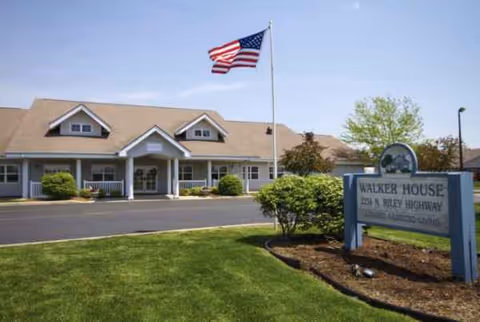 Exterior view of Walker Place senior living facility with American flag and front sign.