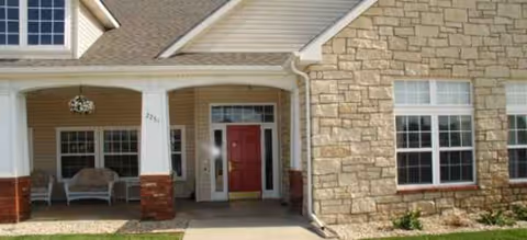Front entrance of Brookdale Salina Fairdale with porch seating and stone exterior.