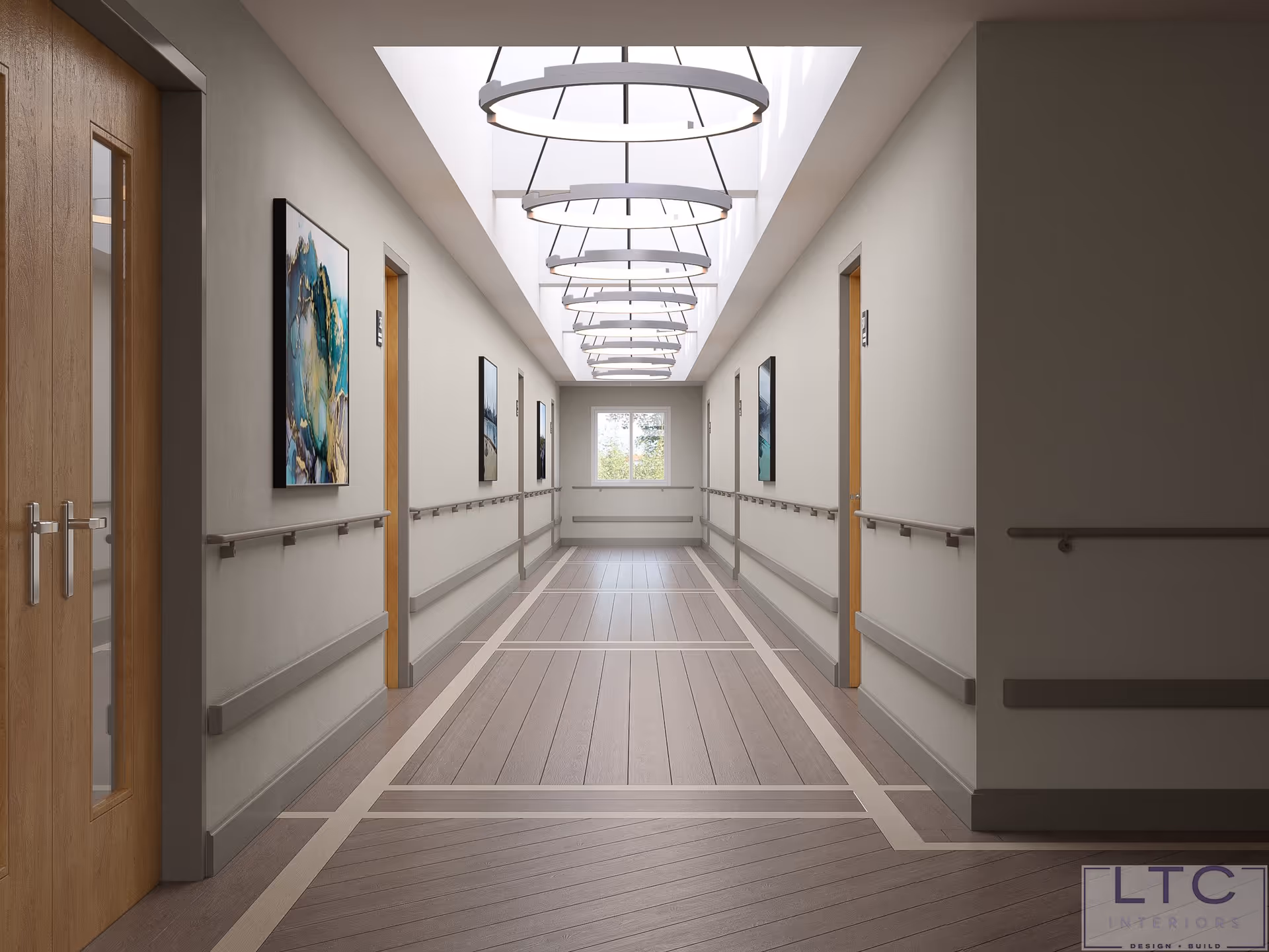 A well-lit, modern hallway in a healthcare facility with wooden doors on both sides, handrails along the walls, abstract artwork hanging on the walls, and circular ceiling lights. A window is visible at the end of the corridor.
