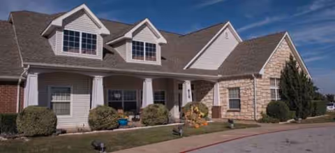 Front exterior of Brookdale Midwestern senior living building with manicured shrubs and walkway.
