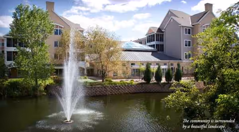 Exterior view of The Commons on Marice with a fountain, pond, and landscaped grounds.