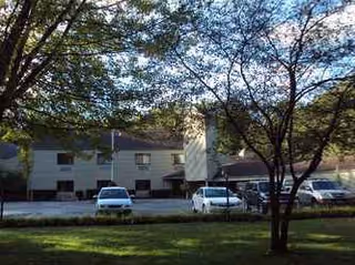 Exterior view of Westlake Assisted Living with parked cars and trees in foreground.