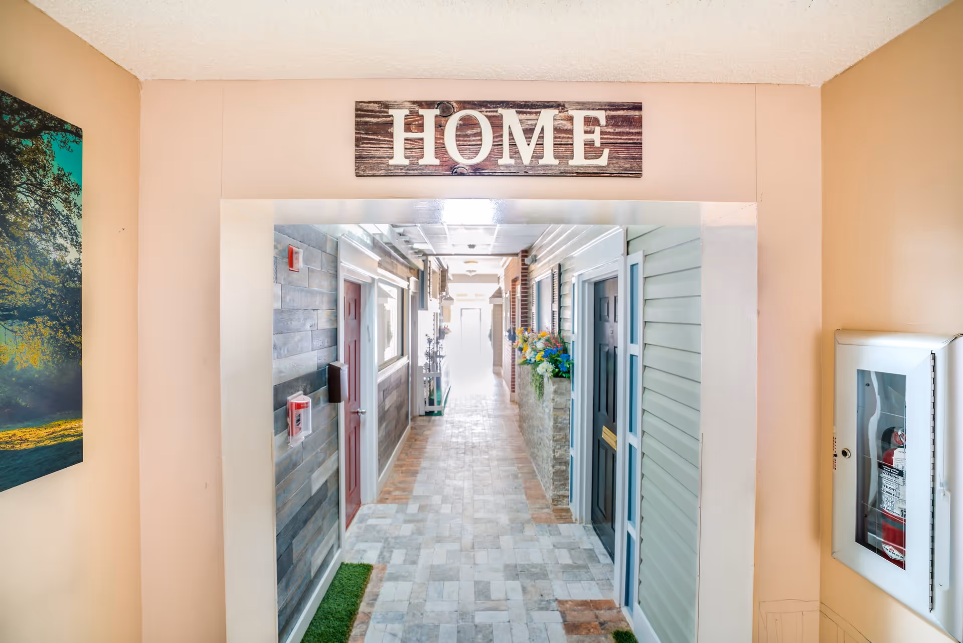 Indoor hallway styled like a small row of apartment doors with a wooden 'HOME' sign above the entry.