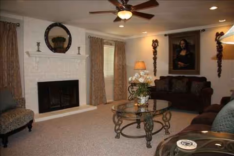 Living room in Gift of Grace Care Home with fireplace, seating, and artwork.